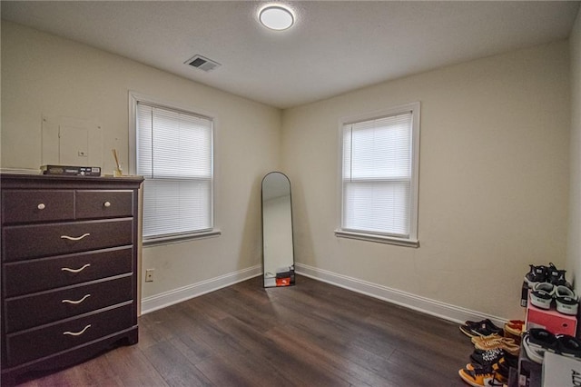 bedroom with baseboards, visible vents, and dark wood-style flooring