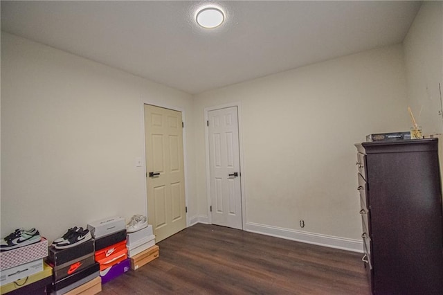 interior space with baseboards and dark wood finished floors