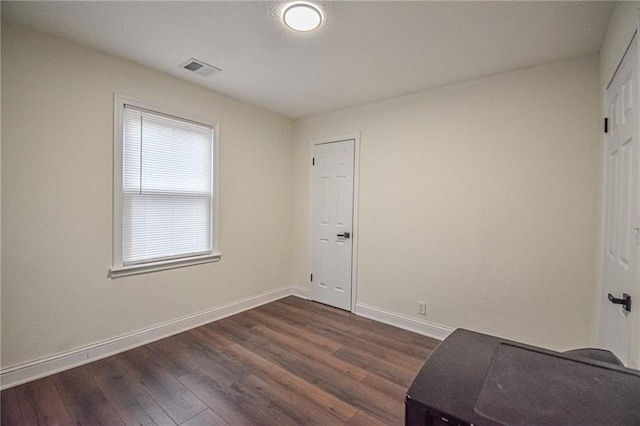 unfurnished bedroom with visible vents, baseboards, and dark wood-style flooring