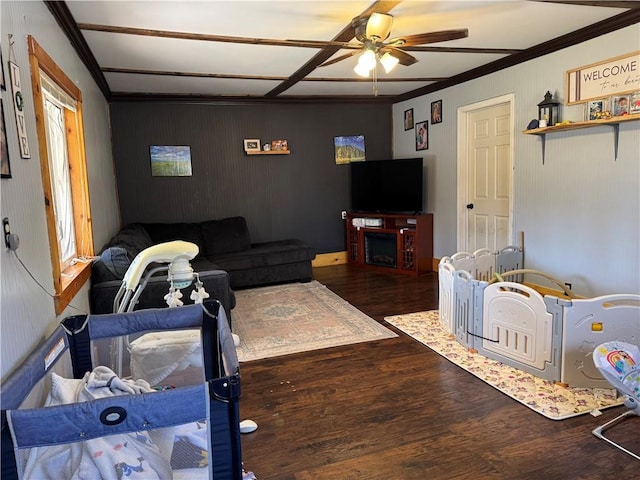 living room featuring ornamental molding, a fireplace, a ceiling fan, and wood finished floors