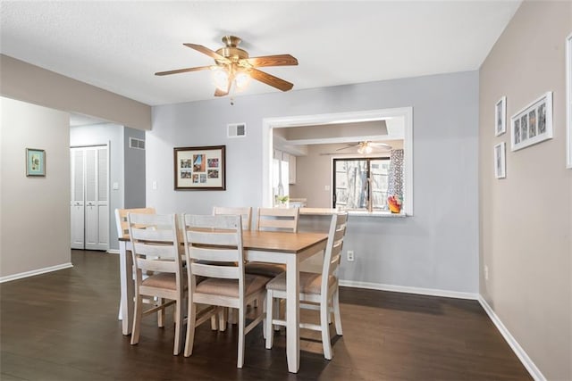 dining area featuring dark wood-type flooring, baseboards, and visible vents