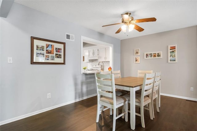 dining room with visible vents, baseboards, dark wood-type flooring, and ceiling fan