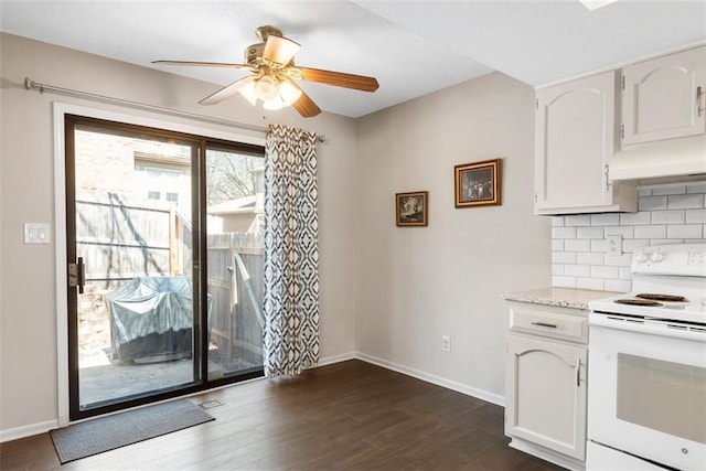 kitchen featuring dark wood-type flooring, white range with electric cooktop, tasteful backsplash, white cabinets, and baseboards