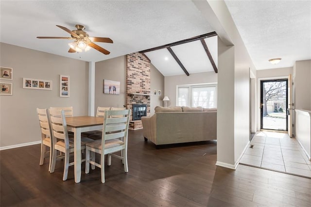 dining space with plenty of natural light, a textured ceiling, lofted ceiling with beams, and hardwood / wood-style flooring