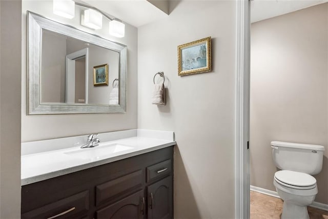 half bath with baseboards, toilet, vanity, and tile patterned flooring