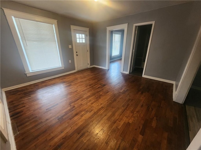 foyer with dark wood-style floors and baseboards