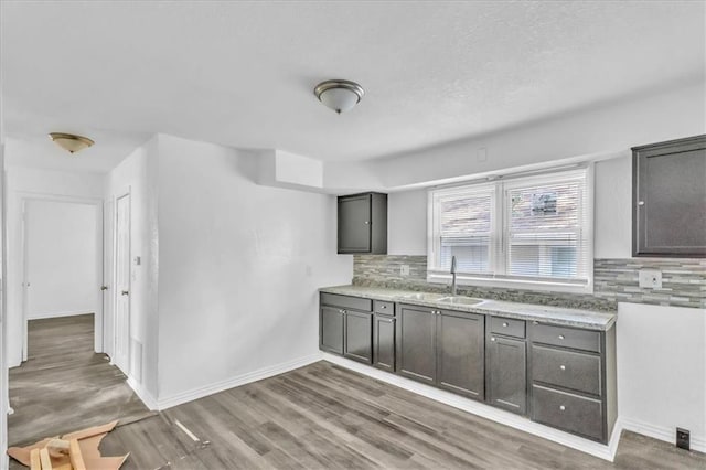3309 E 69th St, Kansas City, MO 64132 - kitchen featuring a sink, tasteful backsplash, gray cabinetry, and wood finished floors