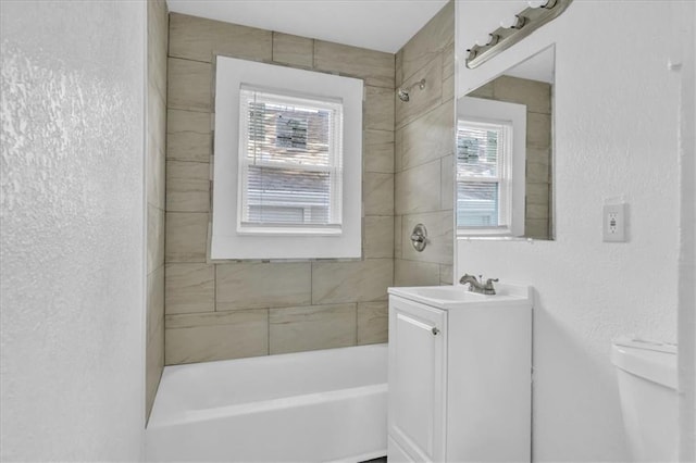 3309 E 69th St, Kansas City, MO 64132 - bathroom featuring toilet, vanity, shower / bathing tub combination, and a textured wall