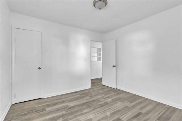3309 E 69th St, Kansas City, MO 64132 - spare room with baseboards and wood finished floors
