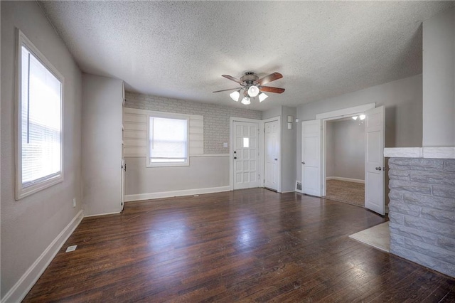 unfurnished living room featuring baseboards, a textured ceiling, ceiling fan, and wood finished floors