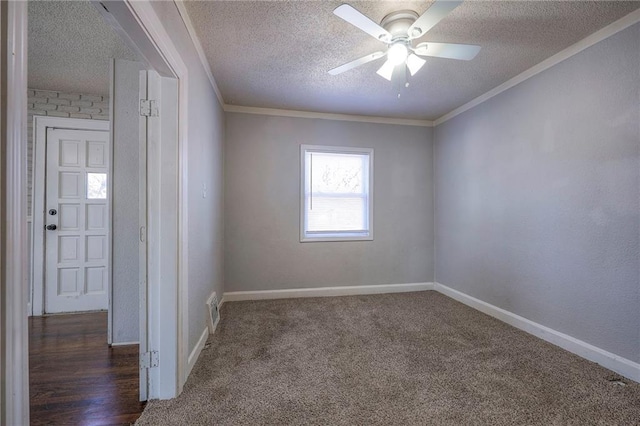 carpeted empty room with visible vents, baseboards, a textured ceiling, and ornamental molding