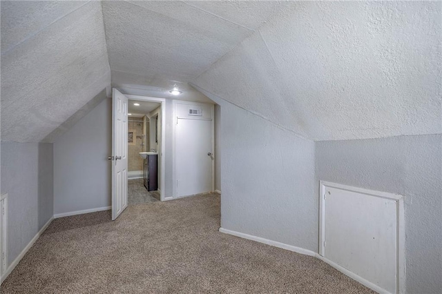 bonus room featuring baseboards, a textured ceiling, carpet, and lofted ceiling