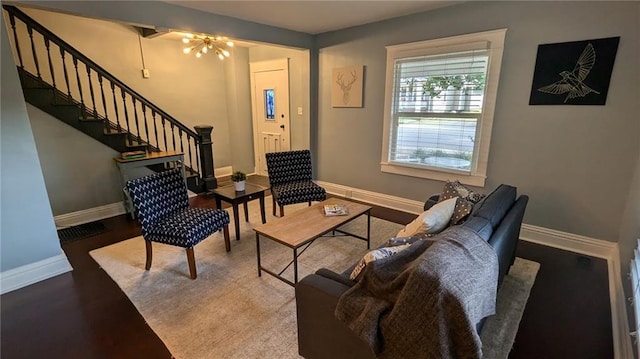 living room with stairs, visible vents, wood finished floors, and baseboards