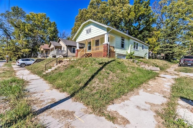 bungalow-style home with a porch and a front yard