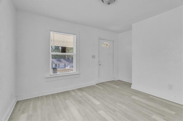 spare room featuring baseboards and wood finished floors