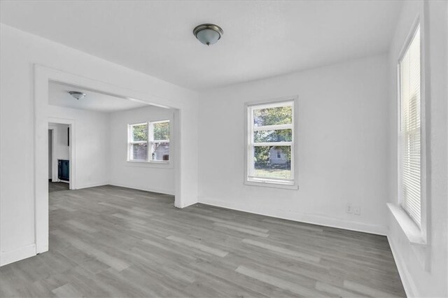 spare room featuring baseboards and wood finished floors