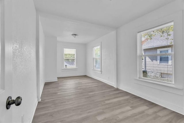 unfurnished room with baseboards and wood finished floors