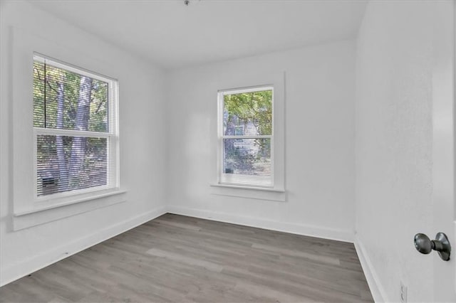 unfurnished room with wood finished floors and baseboards