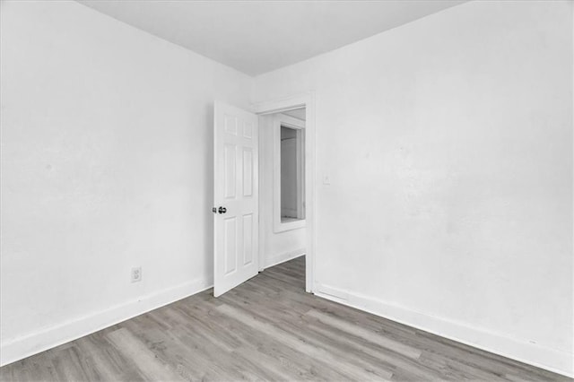 unfurnished room with baseboards and wood finished floors