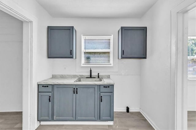 interior space featuring wood finished floors, baseboards, and a sink