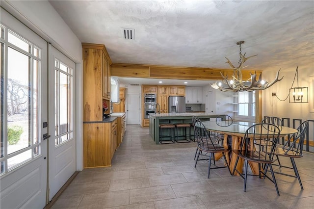 dining room with visible vents and a notable chandelier