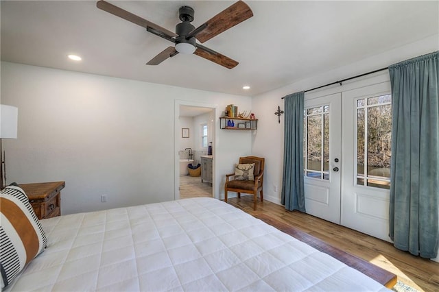 bedroom featuring wood finished floors, recessed lighting, french doors, and ensuite bathroom