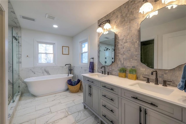 full bathroom featuring tile walls, visible vents, marble finish floor, and a sink