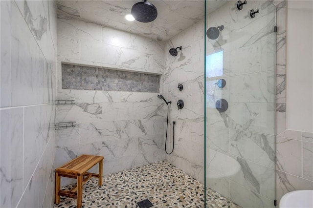 full bathroom with a tile shower and tile walls