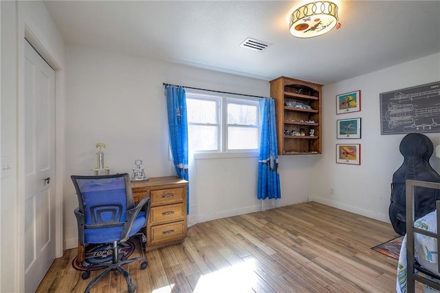 office space featuring visible vents, baseboards, and light wood-style floors