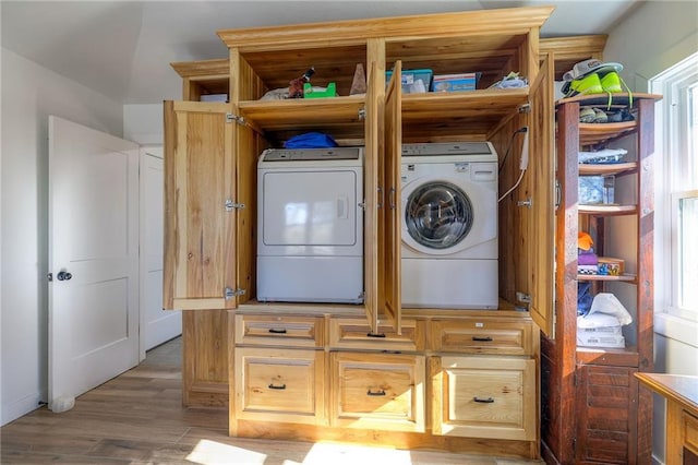 laundry area featuring washer and dryer, light wood-style flooring, and laundry area