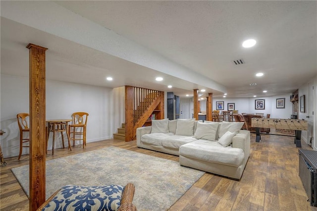 living room with stairway, recessed lighting, wood finished floors, and visible vents