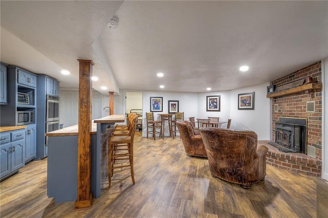 living area featuring recessed lighting, a textured ceiling, and wood finished floors