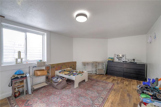 bedroom featuring a textured ceiling and wood finished floors