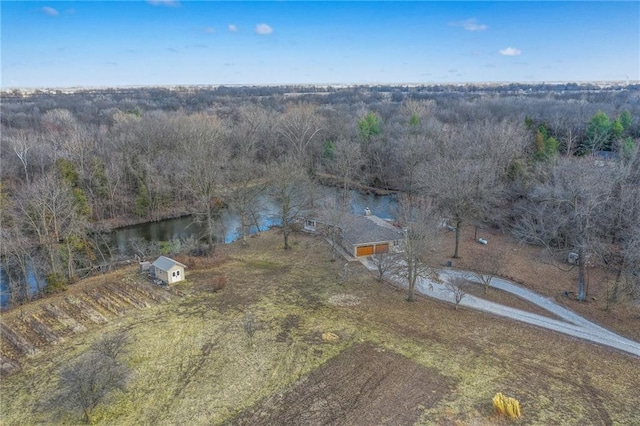 drone / aerial view featuring a forest view and a water view