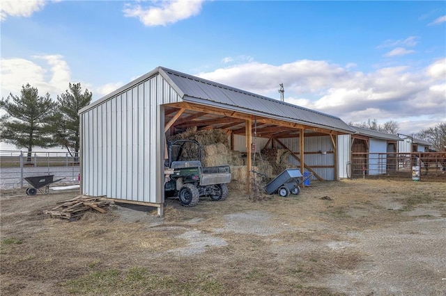 view of pole building featuring a detached carport and fence