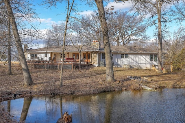 350 NW 71p Rd, Clinton, MO 64735 - rear view of property with covered porch, a water view, board and batten siding, and a chimney
