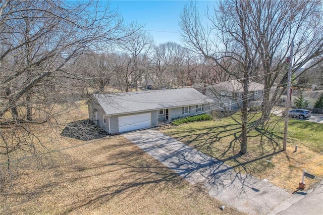 single story home with aphalt driveway, a garage, and a front yard