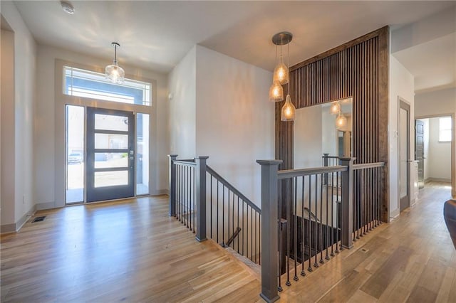 entryway with wood finished floors, visible vents, and baseboards