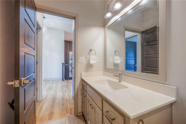 bathroom featuring vanity, baseboards, and wood finished floors