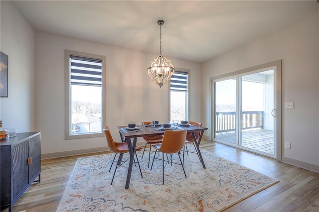 dining room with an inviting chandelier, light wood finished floors, and a wealth of natural light