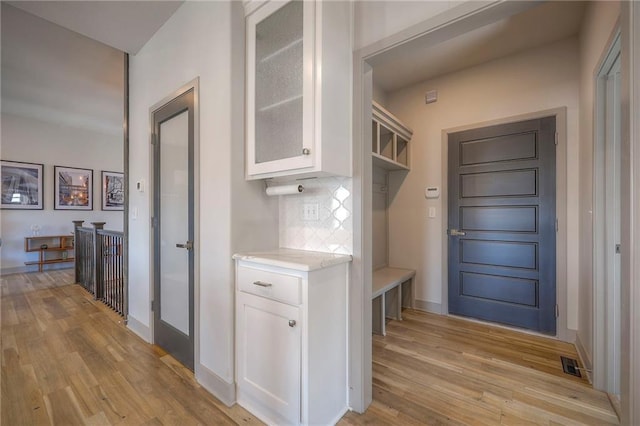 mudroom featuring visible vents, baseboards, and light wood-style floors