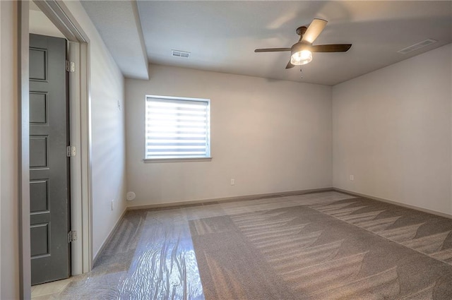 unfurnished room featuring carpet flooring, a ceiling fan, visible vents, and baseboards