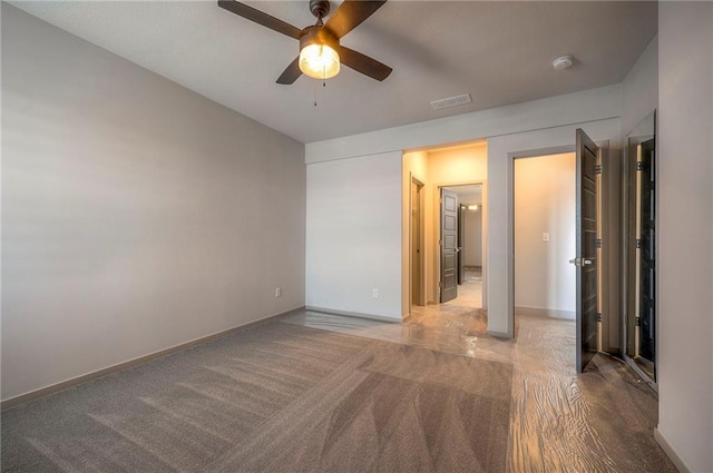 unfurnished bedroom featuring carpet flooring, visible vents, baseboards, and ceiling fan