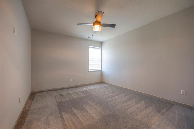 carpeted spare room with baseboards and a ceiling fan