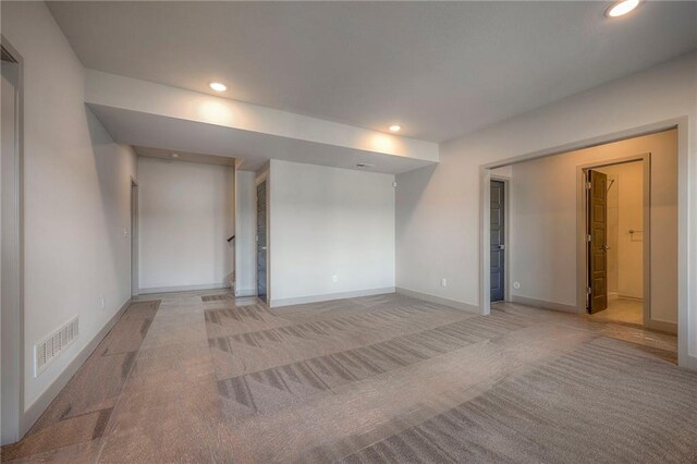 empty room featuring recessed lighting, visible vents, light colored carpet, and baseboards