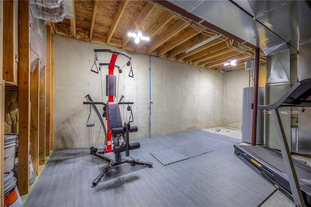 exercise area featuring wood finished floors and water heater