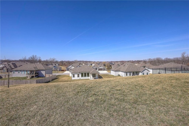 back of house with a yard, fence, and a residential view