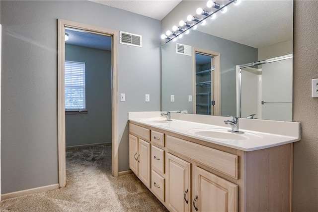 bathroom with baseboards, visible vents, and a sink