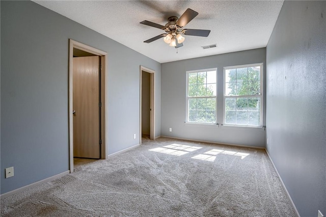 unfurnished bedroom with visible vents, a textured ceiling, baseboards, and carpet floors