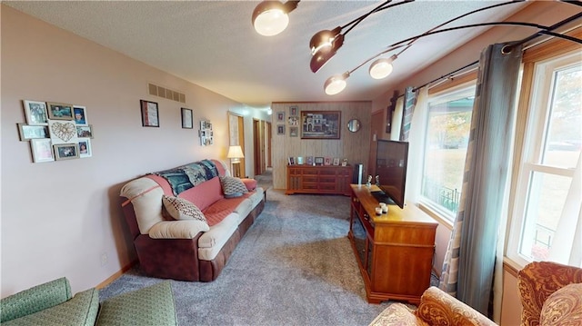 carpeted living room with visible vents and a textured ceiling